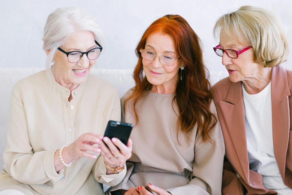 3 ladies looking at a mobile phone